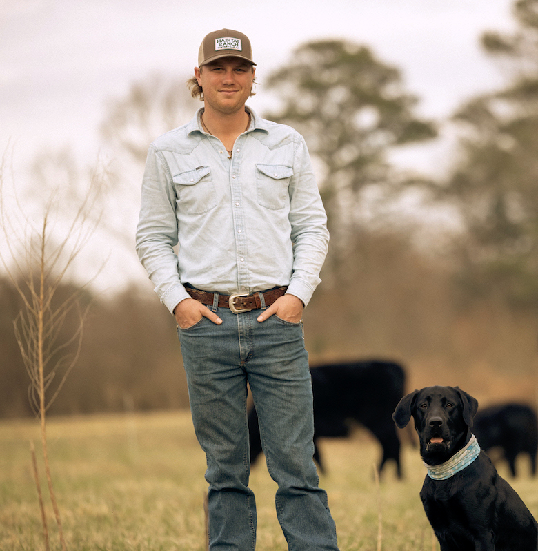 Regenerative rancher, Clint McNeal, stands with his herd of cows and his dog.